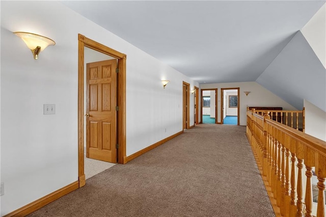 hallway featuring light colored carpet and vaulted ceiling