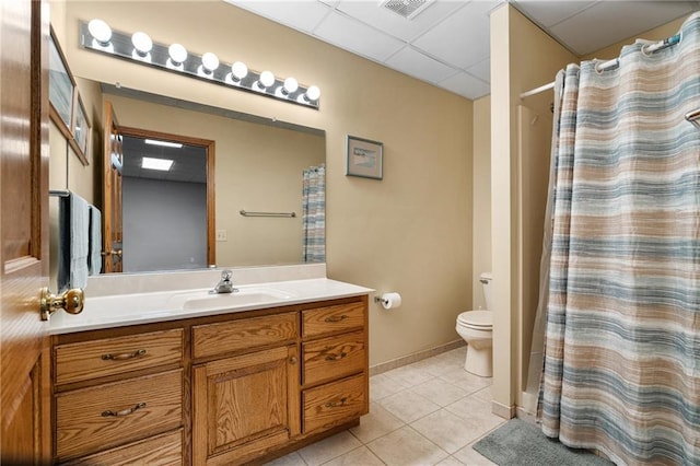 bathroom featuring a paneled ceiling, tile patterned flooring, vanity, toilet, and a shower with curtain