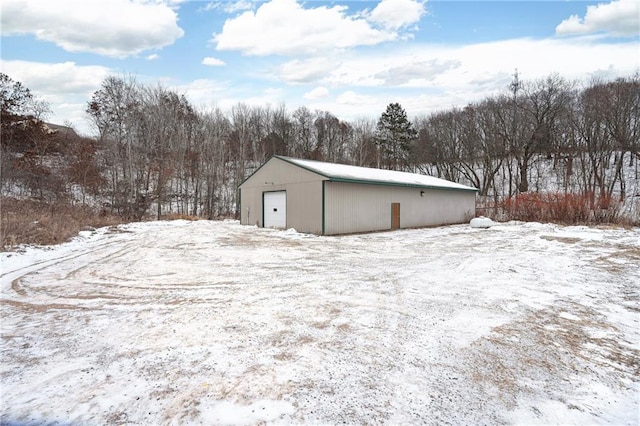 snow covered structure featuring a garage