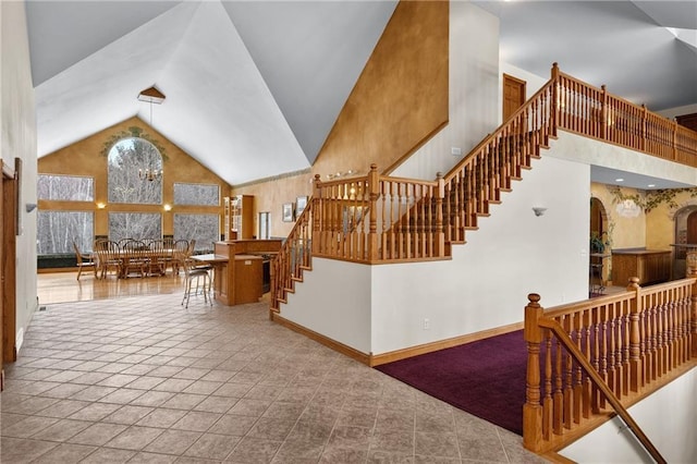 stairs featuring tile patterned flooring and high vaulted ceiling