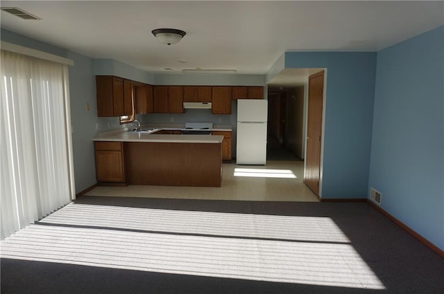 kitchen featuring light carpet, sink, white appliances, and kitchen peninsula