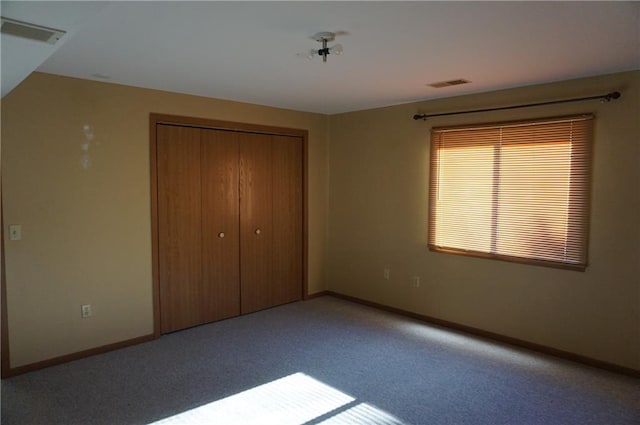 unfurnished bedroom with light colored carpet and a closet