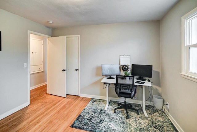 home office with light hardwood / wood-style floors