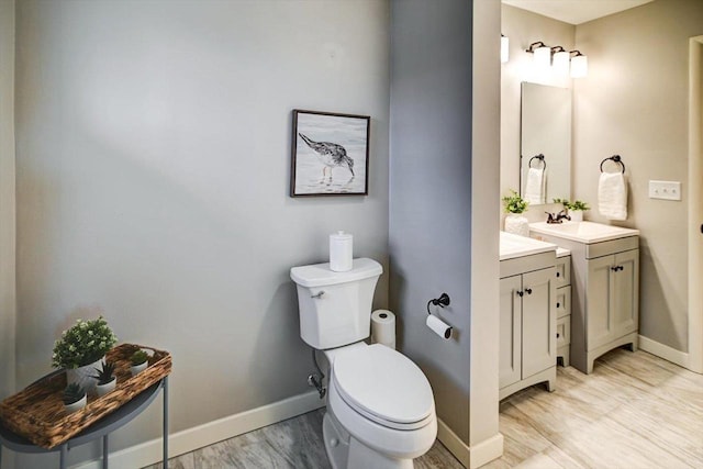 bathroom with vanity, wood-type flooring, and toilet