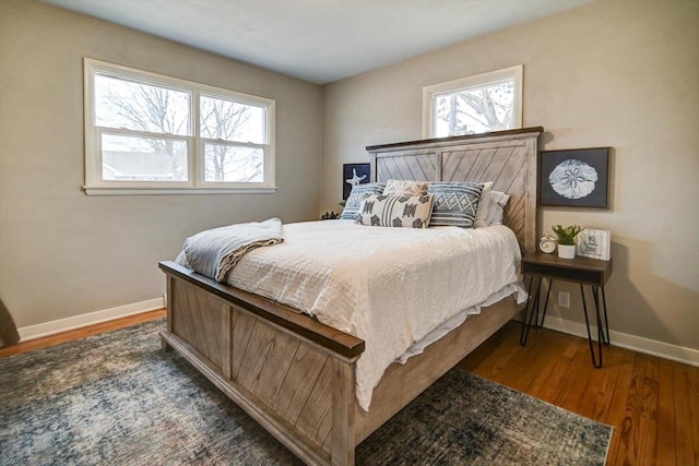 bedroom with multiple windows and dark hardwood / wood-style flooring