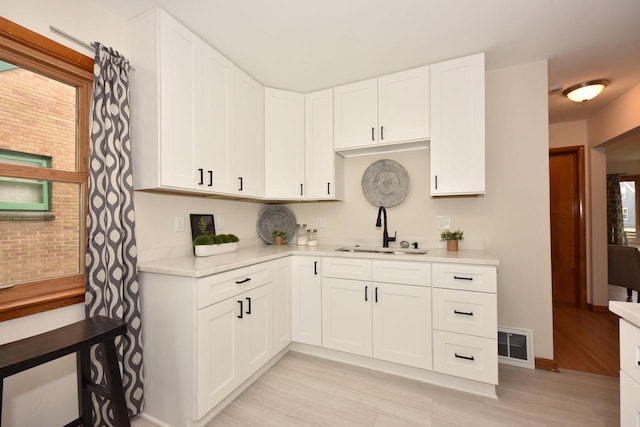 kitchen featuring white cabinetry and sink