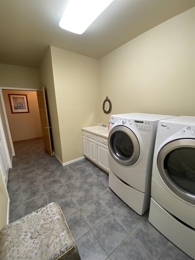 laundry room featuring sink, washer and clothes dryer, and cabinets