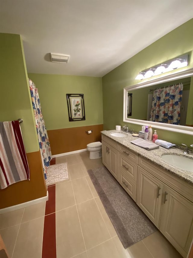 bathroom featuring vanity, tile patterned floors, and toilet