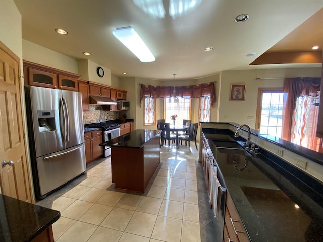 kitchen with pendant lighting, sink, appliances with stainless steel finishes, backsplash, and light tile patterned flooring