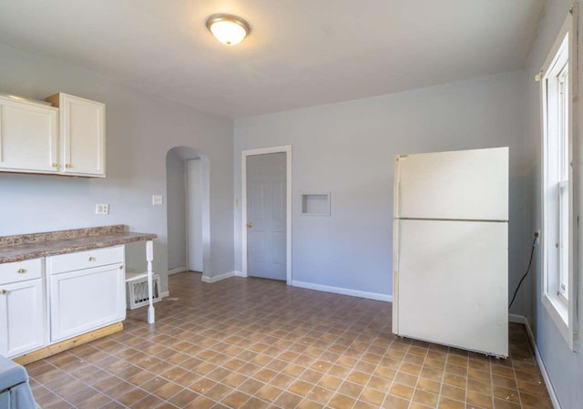 kitchen featuring white refrigerator and white cabinets