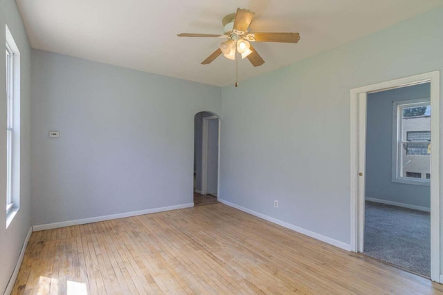 unfurnished room featuring ceiling fan, plenty of natural light, and light wood-type flooring