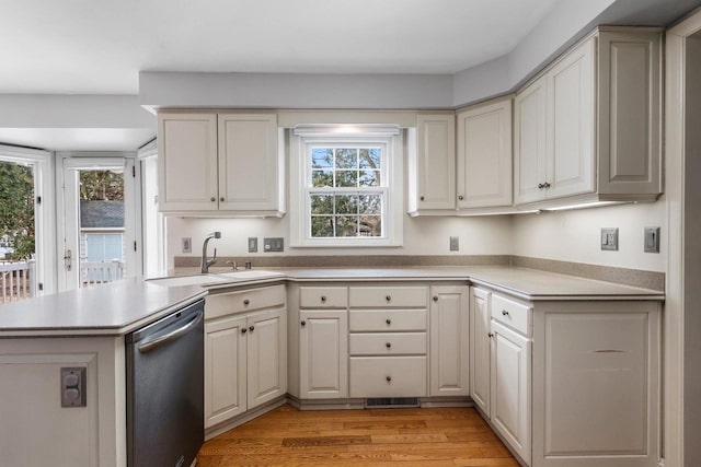 kitchen with plenty of natural light, dishwasher, kitchen peninsula, and light wood-type flooring