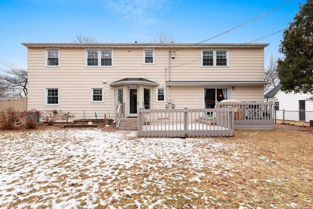 snow covered back of property featuring a deck