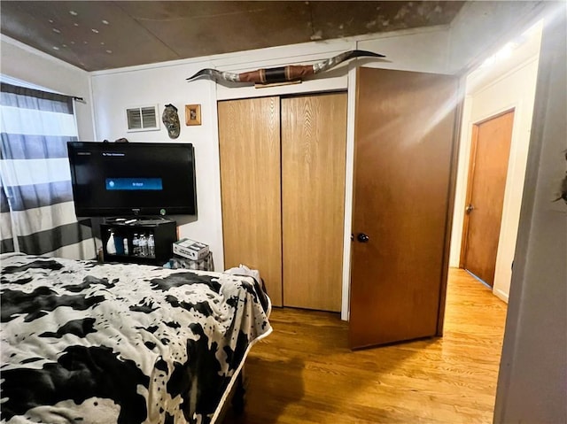 bedroom with hardwood / wood-style floors and a closet