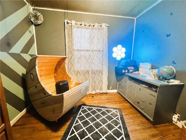 sitting room with crown molding and wood-type flooring