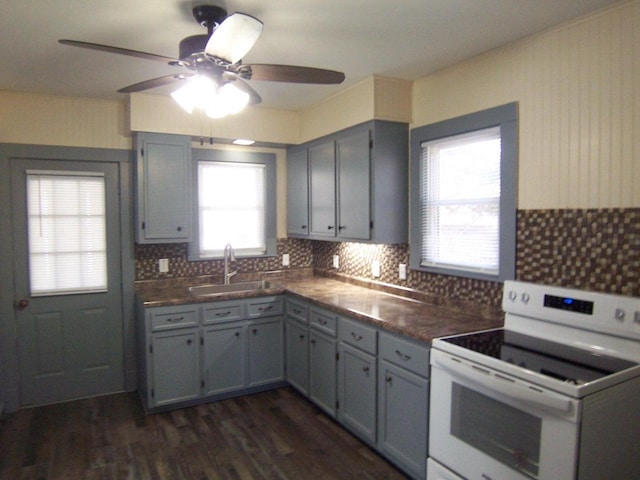 kitchen featuring white electric range oven, sink, dark hardwood / wood-style flooring, gray cabinets, and decorative backsplash