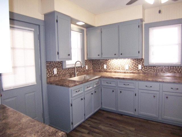 kitchen with tasteful backsplash, dark wood-type flooring, gray cabinets, and sink