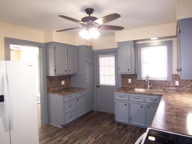 kitchen with sink, tasteful backsplash, dark hardwood / wood-style floors, gray cabinets, and white refrigerator with ice dispenser