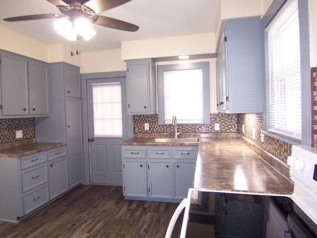 kitchen with sink, dark wood-type flooring, ceiling fan, gray cabinetry, and decorative backsplash