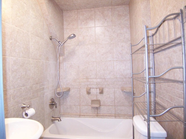 full bathroom featuring tiled shower / bath, toilet, and sink