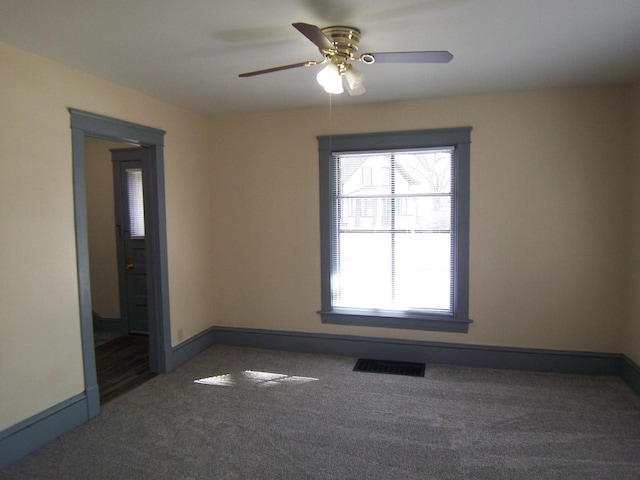 unfurnished room featuring ceiling fan and dark carpet