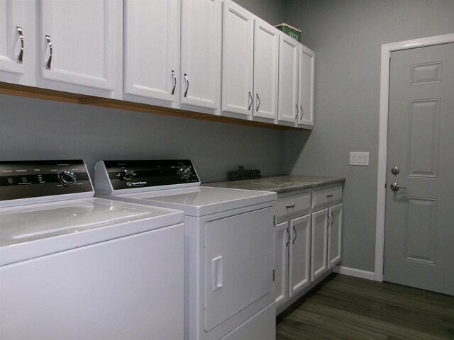 laundry area featuring cabinets, washing machine and dryer, and dark hardwood / wood-style floors