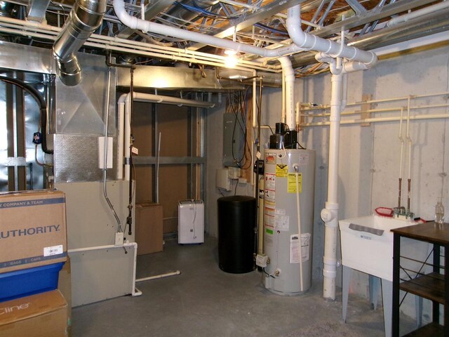 utility room with sink, heating unit, and gas water heater