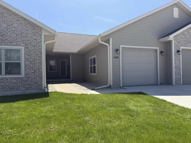 105 Community Dr, Fall River, WI 53932 - view of side of property featuring a garage, a lawn, brick siding, and driveway