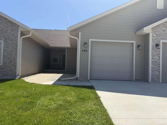 105 Community Dr, Fall River, WI 53932 - property entrance featuring brick siding, an attached garage, concrete driveway, and a lawn