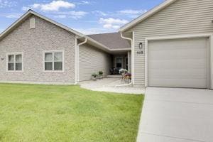105 Community Dr, Fall River, WI 53932 - view of front of home with concrete driveway, a garage, and a front yard
