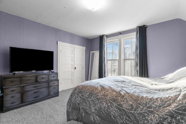 carpeted bedroom featuring lofted ceiling and a closet