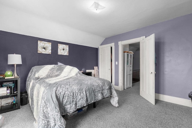 bedroom with carpet floors and vaulted ceiling