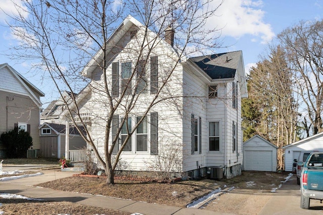 view of front of house with a garage, an outdoor structure, and central AC