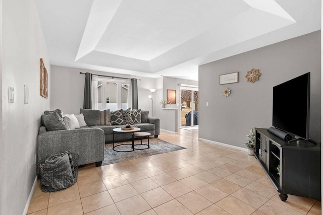 living room with light tile patterned floors and a tray ceiling