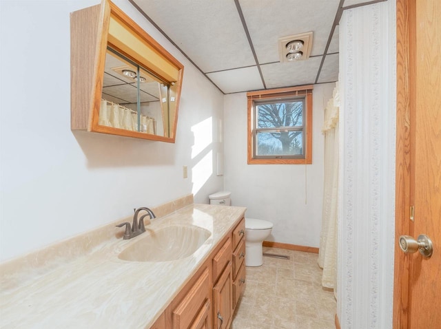 bathroom featuring vanity, a paneled ceiling, and toilet