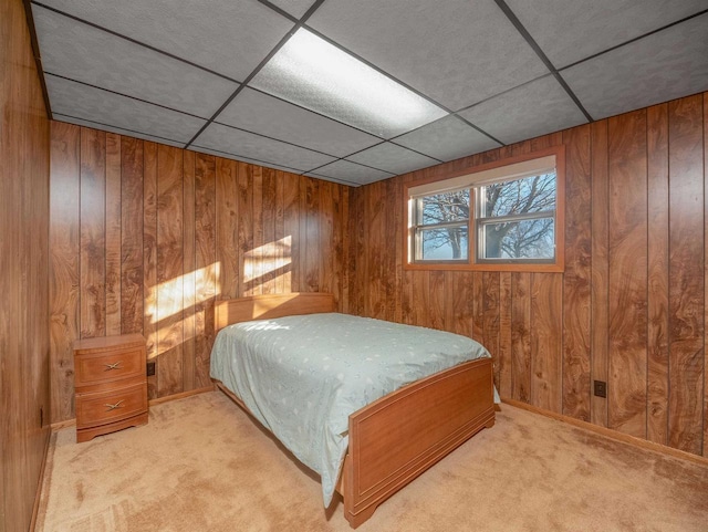 carpeted bedroom featuring wood walls