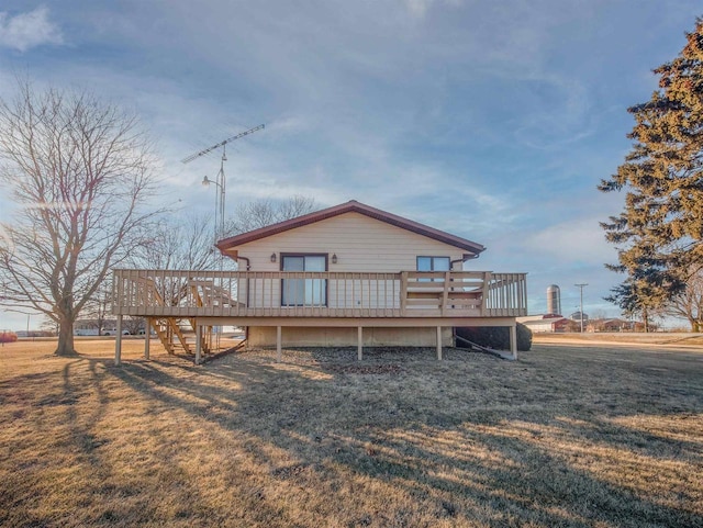 rear view of property featuring a yard and a deck