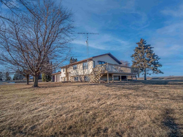 back of house featuring a wooden deck and a lawn