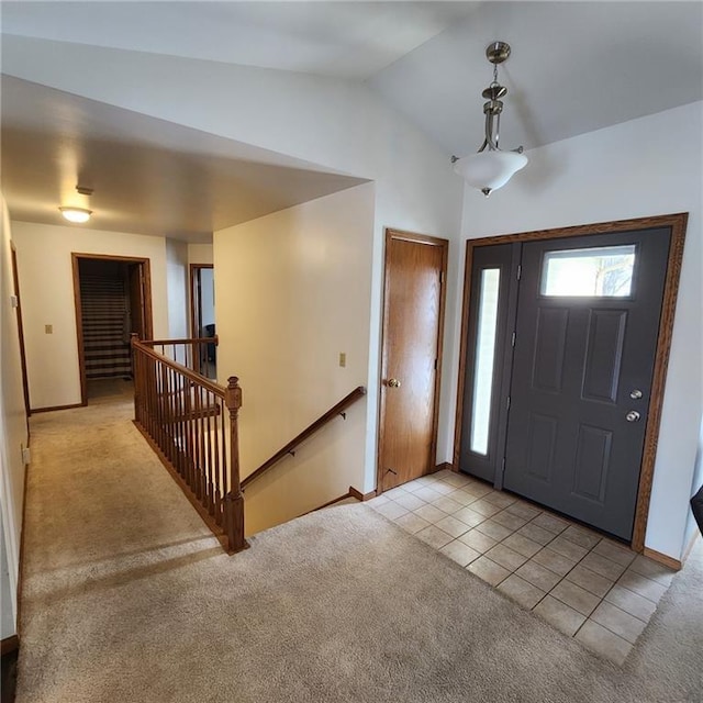 foyer with light tile patterned flooring and vaulted ceiling