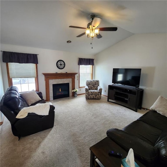 living room featuring lofted ceiling, carpet floors, a tile fireplace, and ceiling fan