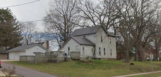 view of front facade featuring a wooden deck, a garage, and a front lawn