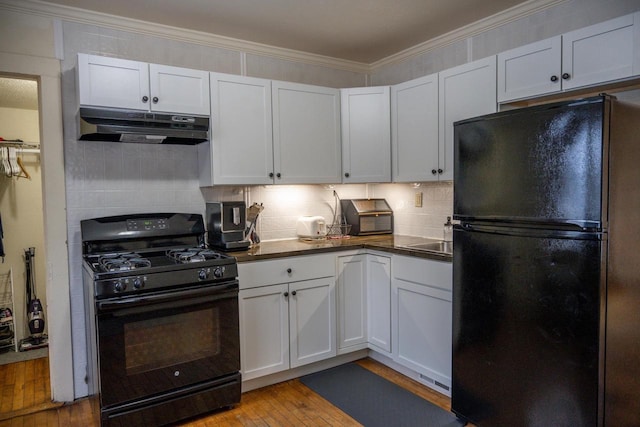 kitchen with tasteful backsplash, black appliances, light hardwood / wood-style flooring, ornamental molding, and white cabinets