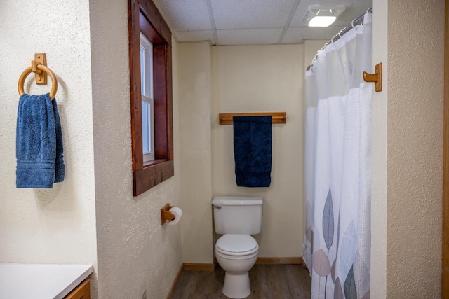 bathroom with hardwood / wood-style flooring, a paneled ceiling, a shower with shower curtain, vanity, and toilet