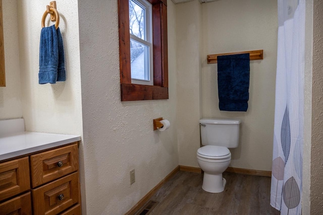 bathroom featuring hardwood / wood-style flooring, vanity, and toilet