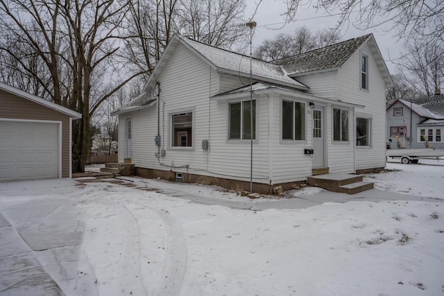 view of snow covered exterior with an outbuilding and a garage