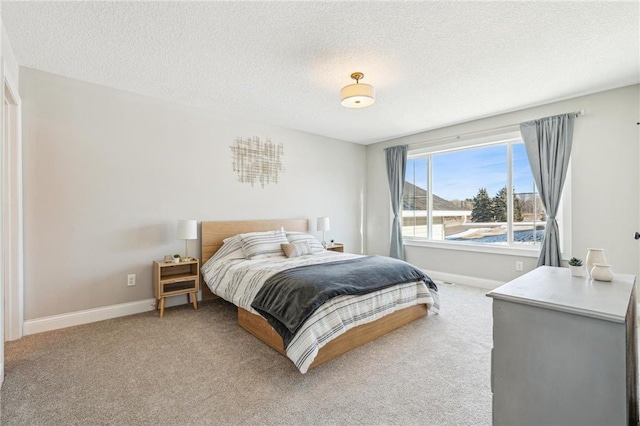 bedroom featuring light colored carpet and a textured ceiling