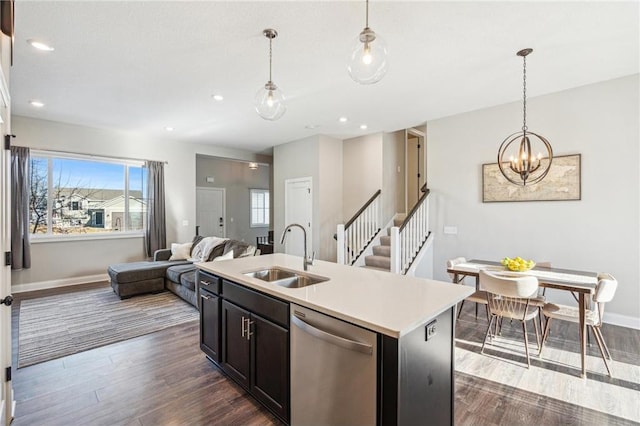 kitchen with dark hardwood / wood-style floors, dishwasher, an island with sink, sink, and hanging light fixtures