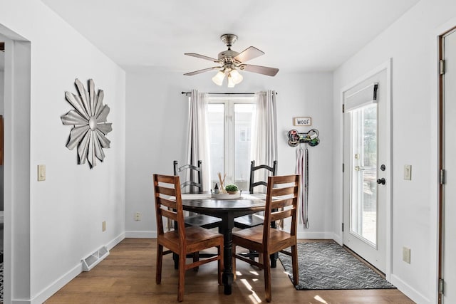 dining space featuring ceiling fan, plenty of natural light, and dark hardwood / wood-style flooring