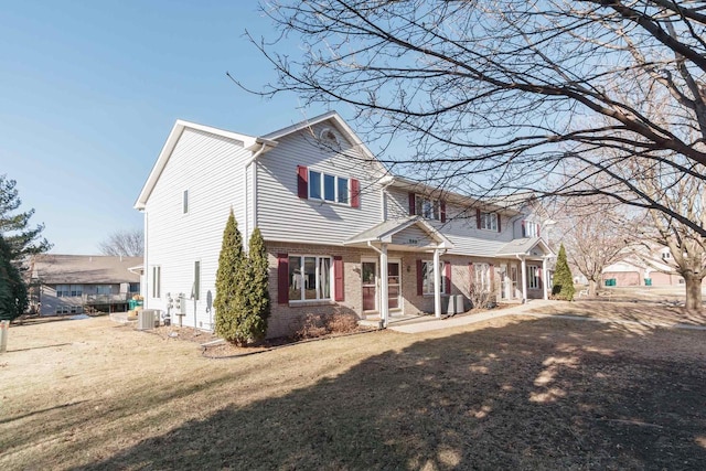 view of front of property featuring central AC unit and a front lawn