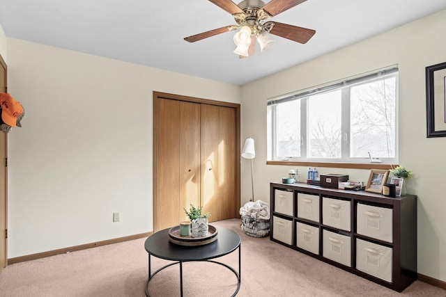 sitting room with ceiling fan and light colored carpet